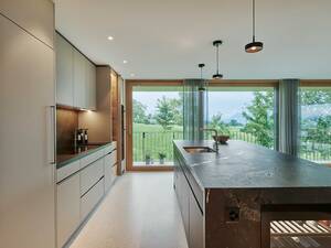 Als verbindendes Element wurde in dieser Küche die Rückwand beim Kochen sowie die Nische der Insel mit Messing ausgearbeitet. Der Negresco Granit wurde so bearbeitet, dass er eine lederne Oberflächenstruktur aufweist. Brunner Küchen AG.