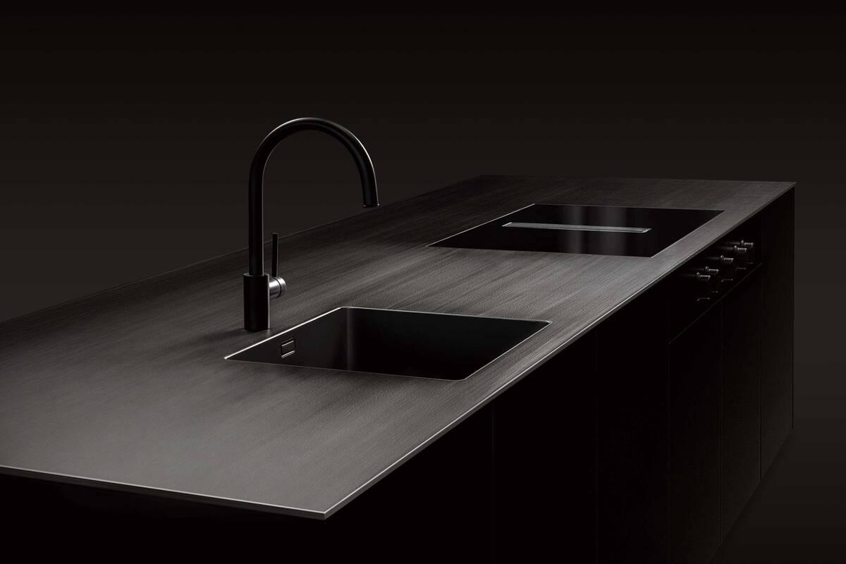 Basis für die Küchenabdeckung «Vulcano» ist eine warmgewalzte Platte aus Edelstahl in 5 oder 8 mm, welche mit einer keramischen Beschichtung geschwärzt wird. Morath AG Design.