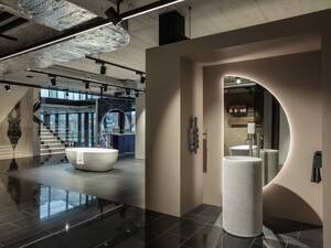 Die bodenstehende Waschtischsäule «Introverso» von Antonio Lupi ist aus dem edlen Marmor Bianco Carrara gefertigt. Ein besonderes Highlight ist der beleuchtete Spiegel «Spicchio» mit seiner Halbmondform. Hans Eisenring Natursteinwerk.