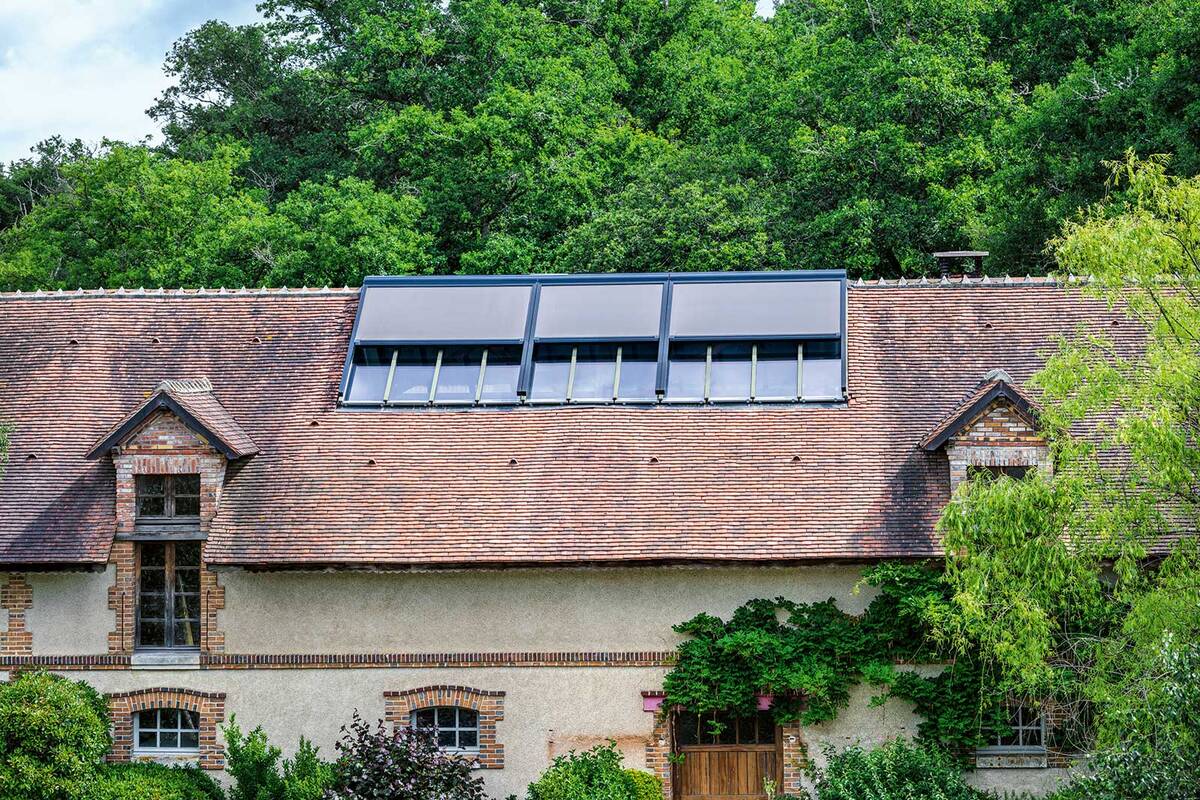 Keine Hitze, trotzdem Licht: Der vertikale Sonnenschutz «Fixscreen Go Solar» von Renson lässt genügend Tageslicht in den Raum, ohne diesen zu überhitzen. Durch die schlanke Ausführung der Tuchkassette liegt der Schattenspender fast unsichtbar auf der Fassade und wirkt elegant. Dank der solarbetriebenen Steuerung sind weder Kabel noch Bohrungen nötig. Renson.