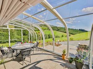 Sonnenstrahlen im Winter: Die gebogene, transparente Dachfläche der Solarveranda «Saphir» bietet einen freien Blick nach draussen. Die Sonnenstrahlen werden gebündelt und verstärkt nach innen geleitet. So wird es im Winter, selbst bei Minusgraden, schnell angenehm warm – ganz ohne Heizung. Wenn es die Aussentemperaturen zulassen, lässt sich die Glasüberdachung weit öffnen. Die Konstruktion ermöglicht es, die Glasüberdachung bei entsprechenden Aussentemperaturen weit zu öffnen und so die Veranda in einen Freisitz zu verwandeln. Vöroka GmbH.