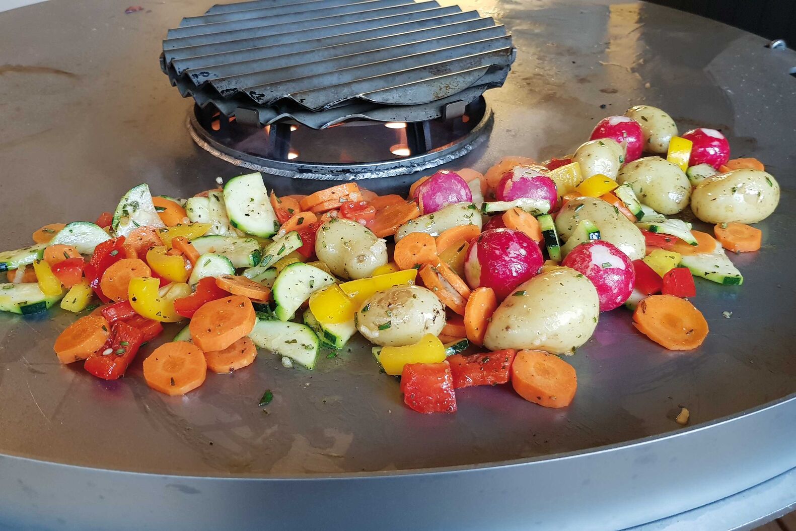 In der Mitte des Pelletgrills kann mit dem Branding-Rost direkt grilliert werden. Die Platte eignet sich für die Zubereitung für Gemüse oder um das Fleisch sachte durchziehen zu lassen. Häussler über Hein Feuerkonzepte. 