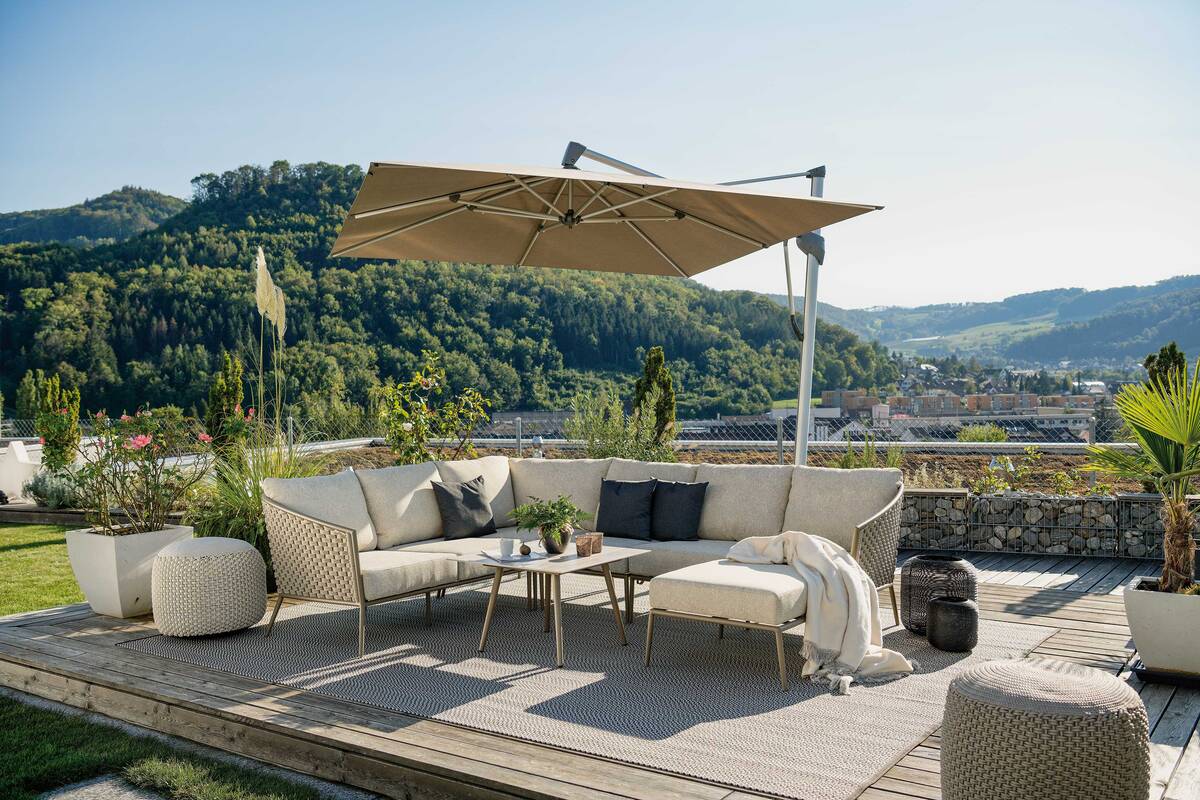 Superheld: Der grosse Schirm «Sombrano S+» richtet sich beim Öffnen über die Kurbel direkt horizontal aus. Dank des seitlich sitzenden Masts lassen sich die Möbel gut arrangieren. Hunn Gartenmöbel.