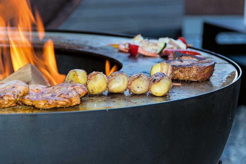 Die halbrunde Kugel des «Feuerball» lässt sich drehen, der Rost ist höhenverstellbar und bietet Platz für Töpfe, Pfannen und Grillgut. Der Grill ist in zwei Grössen erhältlich, das Material rostet entweder natürlich oder kommt in Mattschwarz. Das Umbau-Kit verwandelt den Grill zur Feuerschale. Chromtech AG, www.chromtech-ai.ch