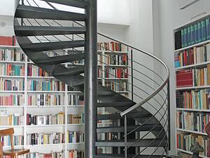 Spindeltreppe mit abgekanteten Blechstufen und Traversengeländer aus schwarzem, rohem Stahl. Handlauf in Chromnickelstahl. Ferdinand Hasler AG.