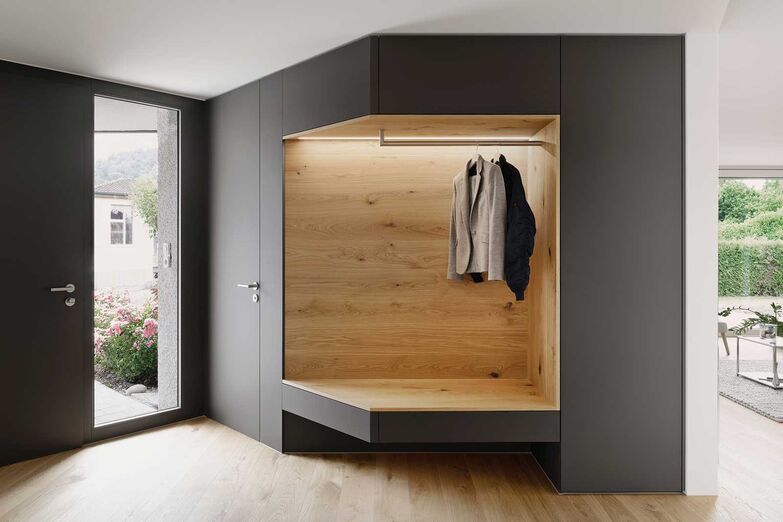 Das Eichenholz als Bodenbelag und in der Garderobe verleiht dem Eingangsbereich eine einheitliche Harmonie. Das Bekenntnis zur Materialität wurde auch im restlichen Haus konsequent umgesetzt.