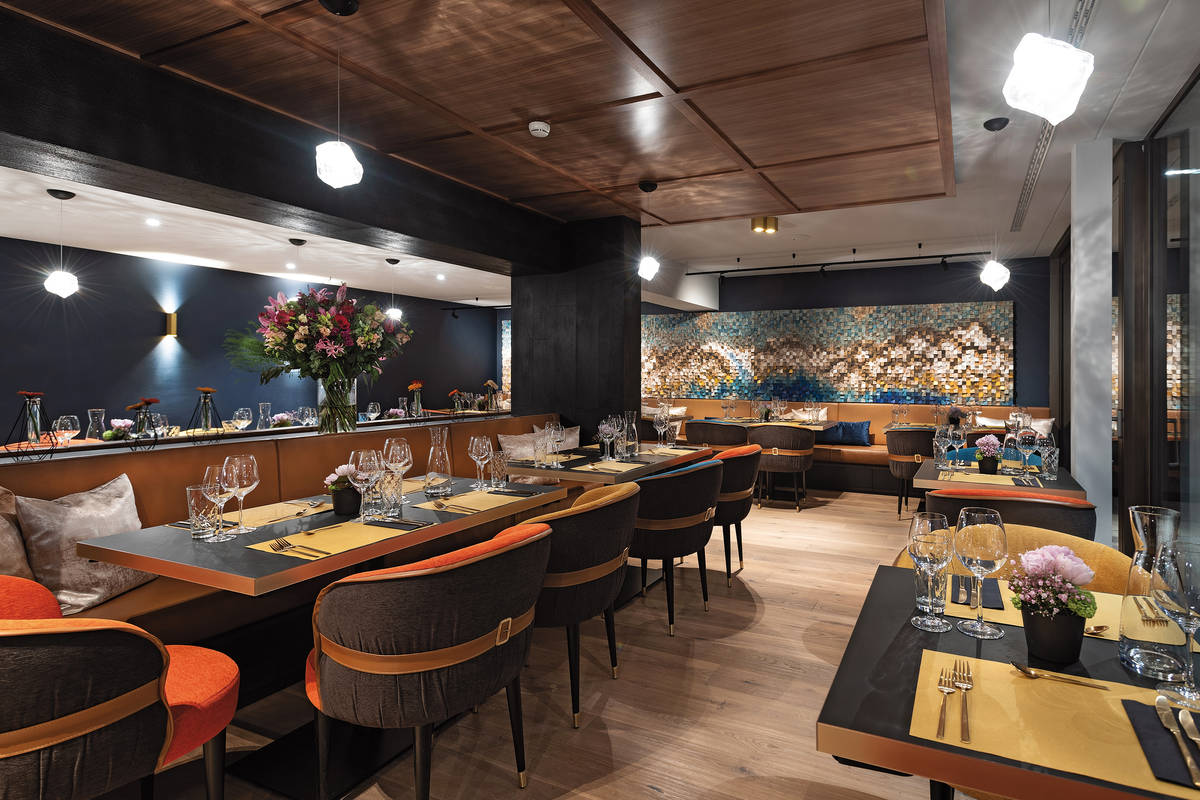 Im Restaurant spiegelt das kunstvolle Wandelement aus bunten Holzwürfeln die Bergwelt wider.