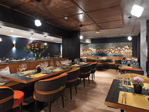Im Restaurant spiegelt das kunstvolle Wandelement aus bunten Holzwürfeln die Bergwelt wider.