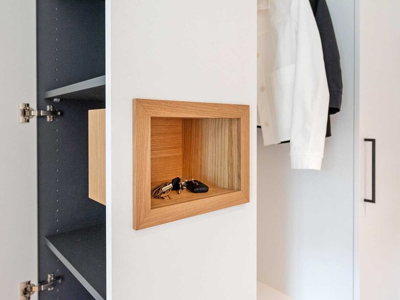 Alltagskunst: Der Schrank von der Schreinerei Fehlmann bietet nicht nur genug Stauraum in der Nähe der Haustür, sondern auch einen designierten Platz für die Schlüssel. Auf einer bequemen Höhe wurde in dem Schrank eine Nische integriert. Mit Eiche furniert und naturlackiert befindet sich die Aussparung dort, wo man intuitiv die Schlüssel ablegen würde. www.schreinerei-fehlmann.ch