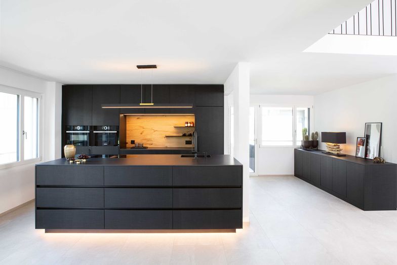 Elegant mit Schwarz: Passend zur Küche gesellt sich ein Sideboard aus dem gleichen Material dazu.