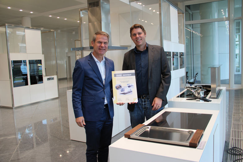 Christian Bärlocher, Head Global Marketing Services V-Zug AG, (links) nimmt von Marcel Hablützel, Head of Sales & Marketing, Etzel Verlag, den Innovationspreis entgegen.