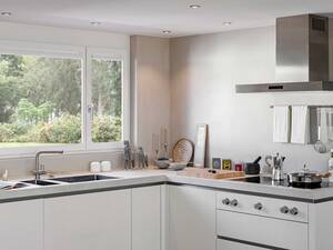 Das Design lebt von der Reduktion: Die Farbpalette beschränkt sich auf kontrastierendes Schwarz und Weiss sowie Chromelemente. Die weiss lackierten Fronten sind grifflos ausgeführt. Herzog Küchen AG.