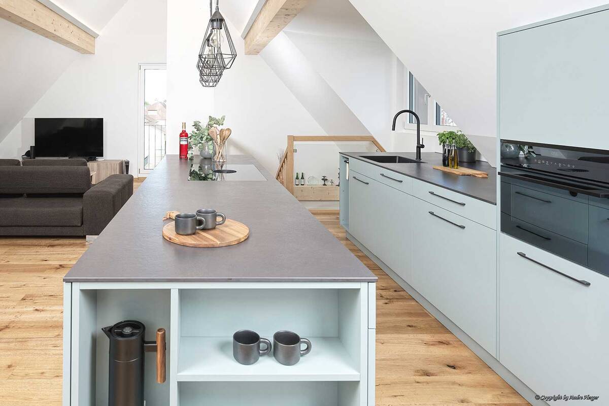 Ein seitlich integriertes Regal am Ende der Kochinsel schafft zusätzlichen, praktischen Stauraum für alltägliche Utensilien auf kleinstem Raum. Veriset AG.