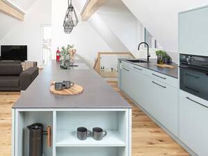 Ein seitlich integriertes Regal am Ende der Kochinsel schafft zusätzlichen, praktischen Stauraum für alltägliche Utensilien auf kleinstem Raum. Veriset AG.