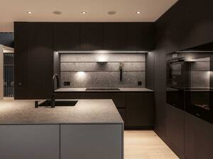 Die Küchenabdeckung und Rückwand aus Keramik in der Farbe «Inalco Meteora» erinnern an eine felsige und eisenhaltige Oberfläche und setzen stimmungsvolle Akzente beim Kochen. Orea AG.