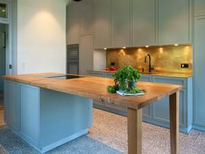 Späti Innenausbau setzt bei dieser individualisierten Küche auf einen ausgewogenen Material- und Farbenmix. Ein Highlight bildet die Arbeitsplatte in «Eiche massiv», die sich über die Kochinsel nahtlos bis hin zum Anbautisch erstreckt. Späti Innenausbau AG.